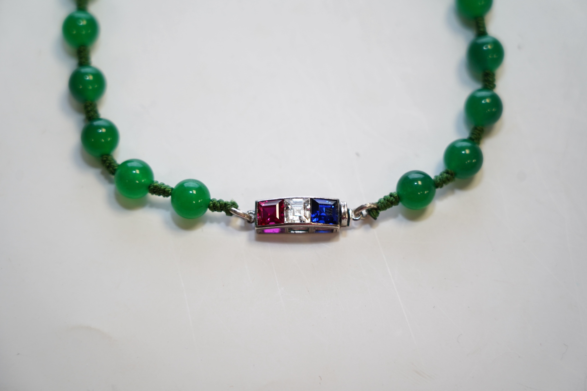 A single strand jadeite bead necklace, with simulated gemstone set clasp, 56cm. Condition - fair